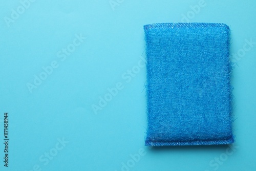 One sponge on light blue background, top view. Space for text