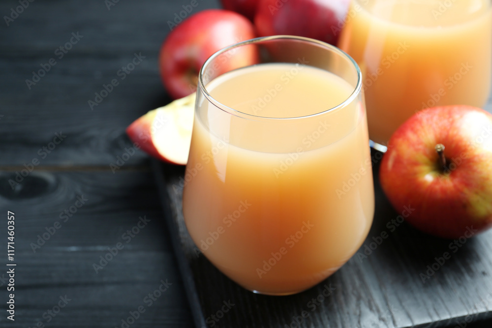 Refreshing apple juice in glass and fruits on black wooden table, closeup. Space for text Refreshing apple juice in glass and fruits on black wooden table, closeup. Space for text