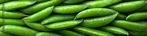 Fresh green sugar snap peas piled together in a vibrant display at a farmer's market during summer harvest season