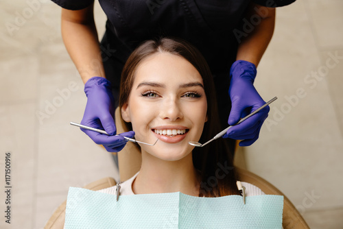 Happy patient during a visit to the dentist. The doctor is checking teeth using a dental instrument, ensuring proper oral care in the dentistry clinic