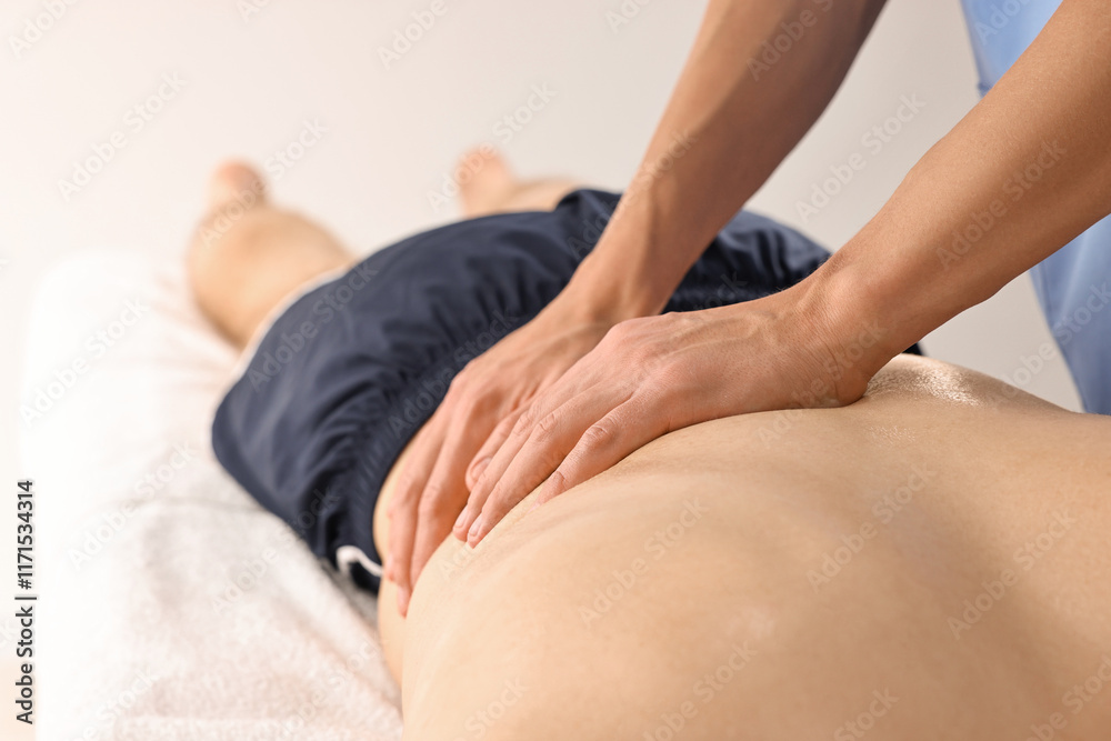 Professional physiotherapist doing back massage for his client indoors, closeup Professional physiotherapist doing back massage for his client indoors, closeup