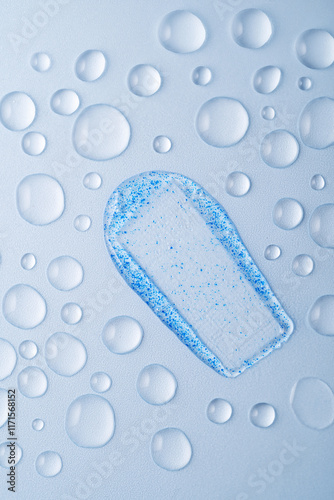 Face scrub smear with blue micro-exfoliating particles close-up photo