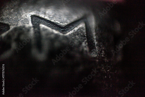 Eyvaz rune, meaning protection of the soul and focuses on the importance of spiritual strength in macro on mettal background	
 photo
