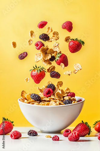 Levitationg ingredients of a muesli fruits cereal breakfast  falling in a white bowl, conceptual and cinematic food photography on a plain yellow background	