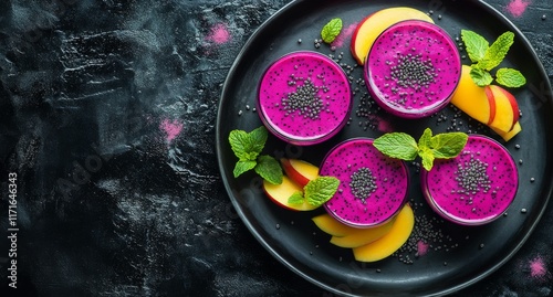 Vibrant dragon fruit smoothies with fresh mango slices and mint leaves served...