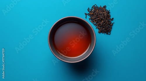 Brewing a rich cup of black tea with loose leaf on a vibrant blue background