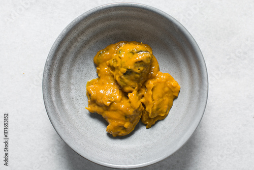 Overhead view of Nigerian owo soup with fish and beef in a grey soup plate, top view of oghwo soup in a grey plate, traditional owo soup in a grey bowl photo