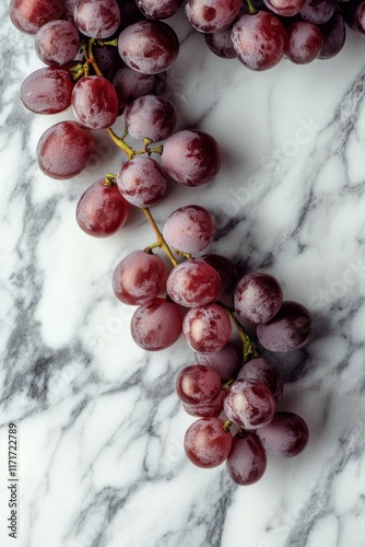 Fresh red grapes on a marble surface showcasing their vibrant color and smoot...