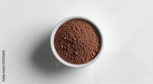 Brown cocoa powder in a white bowl on a light backdrop perfect for baking and...
