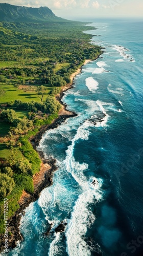 Stunning coastal view showcasing waves crashing on rocks along a lush green s...