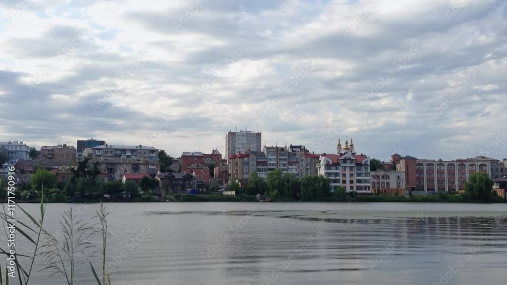 City with a large body of water in the background. The water is calm and the sky is cloudy City with a large body of water in the background. The water is calm and the sky is cloudy
