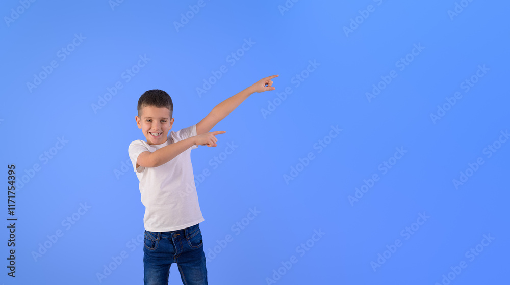 Portrait of smiling cute boy pointing at copy space and promoting new product over blue background Portrait of smiling cute boy pointing at copy space and promoting new product over blue background
