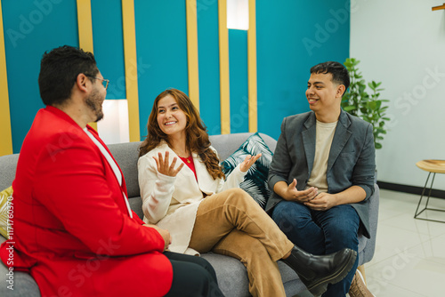 Three colleagues engage in a relaxed conversation in a modern break room, creating a welcoming and professional atmosphere. photo