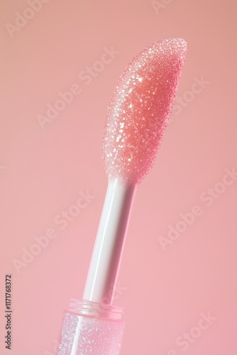 Close-up of a lip gloss applicator with shimmery pink product.