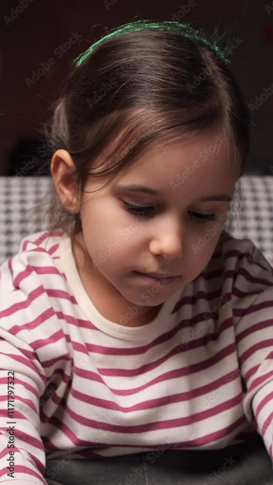 vertical video Little girl playing videogames sitting on armchair at home vertical video Little girl playing videogames sitting on armchair at home