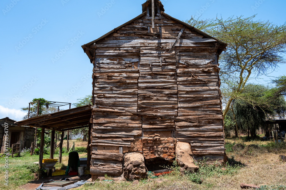 Obraz premium Rustic wood farm building large rocks and brick foundation, split log wood walls, agriculture production on a community farm, Lewa, Kenya, Africa 