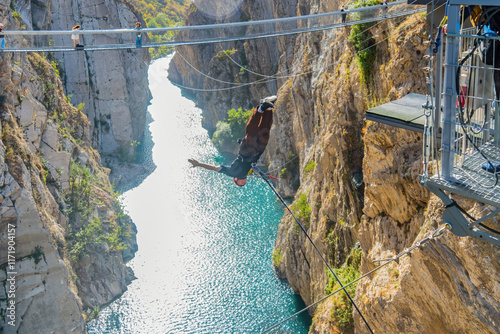 a bungee jumper flying down the canyon and the river below.