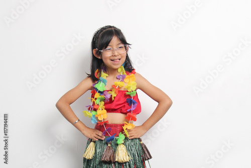 5 year old Latina brunette girl with glasses and Hawaiian skirt enjoys dancing and does Hawaii dance steps very happy and excited photo