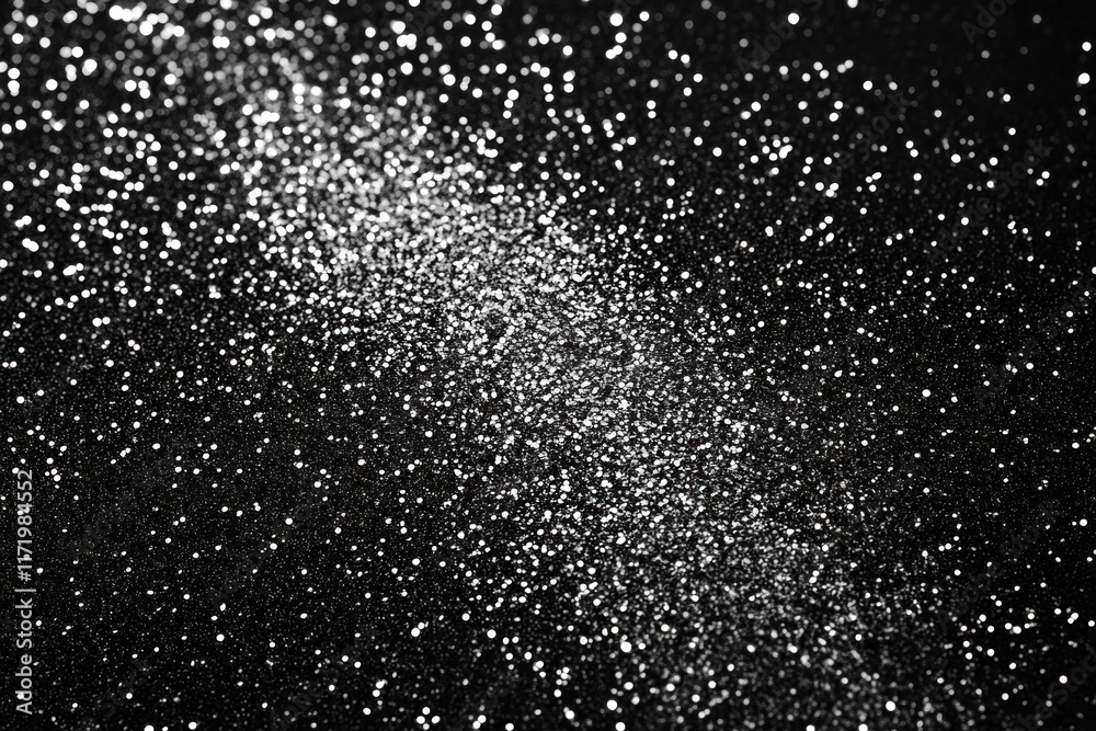 Glitter sparkles on a black background, creating a mesmerizing contrast in a captivating black and white photo. Glitter sparkles on a black background, creating a mesmerizing contrast in a captivating black and white photo.