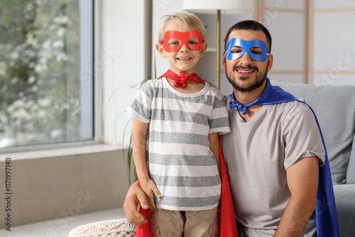 Happy father with his little son dressed as superheroes at home photo