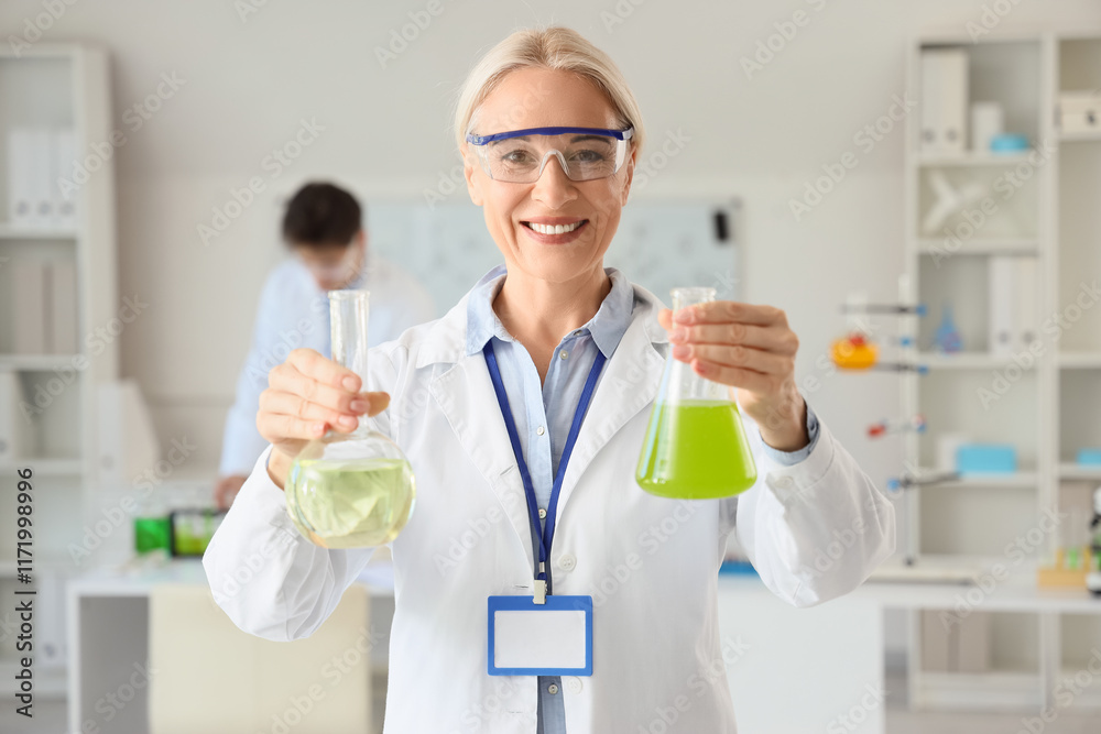 Mature female chemist with flasks in laboratory Mature female chemist with flasks in laboratory