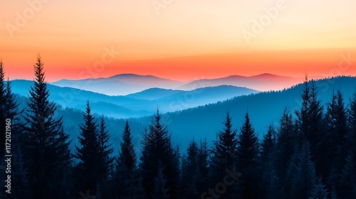 Vibrant sunset over a mountain range with silhouetted evergreen trees in the foreground.