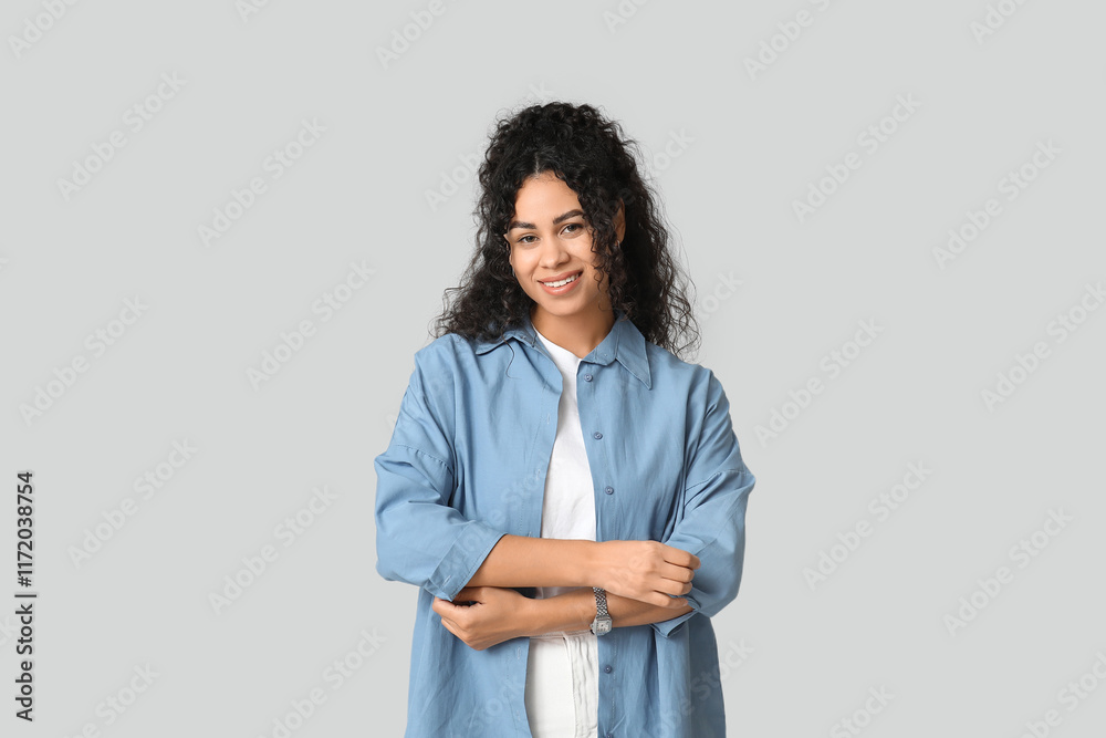 Pretty young African-American woman in stylish blue shirt on white background Pretty young African-American woman in stylish blue shirt on white background