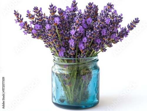 A bouquet of lavender flowers in a blue glass jar. photo