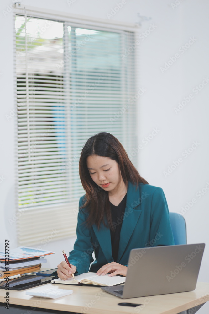 Asian professional businesswoman working on tablet computer in a corporate office Asian professional businesswoman working on tablet computer in a corporate office
