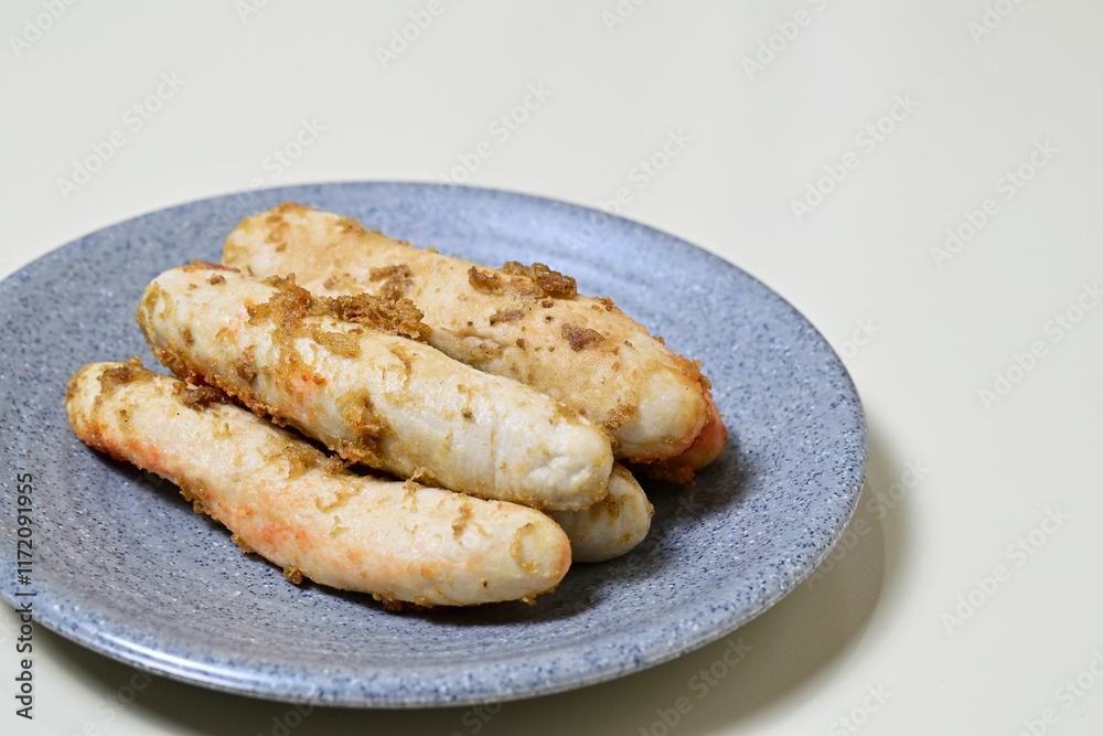 Traditional Indonesian Food, known as otak-otak ikan. Made from fish and served on the grey or gray plate. Close up view. Isolated on white background. Traditional Indonesian Food, known as otak-otak ikan. Made from fish and served on the grey or gray plate. Close up view. Isolated on white background.