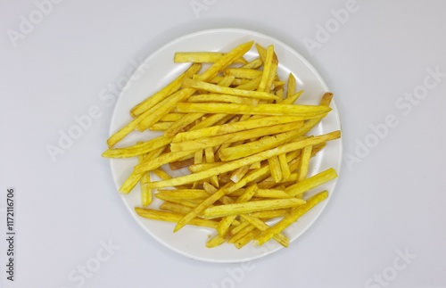 Taro fried sticks isolated in white plate. Asian traditional snack made of taro. Crispy taro chips flat lay background. photo