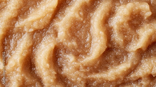 Close-up texture of smooth, creamy applesauce.