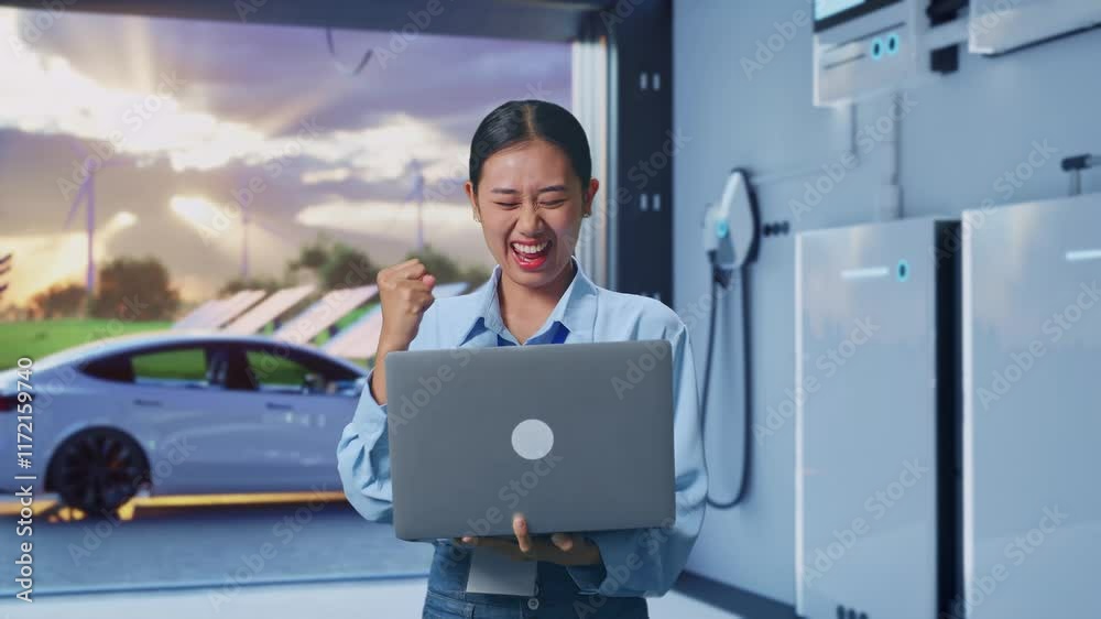 Asian Female With Her Laptop With Home Energy Storage System In a Modern Garage, She Raises Her Fist Up With Screaming Goal Asian Female With Her Laptop With Home Energy Storage System In a Modern Garage, She Raises Her Fist Up With Screaming Goal
