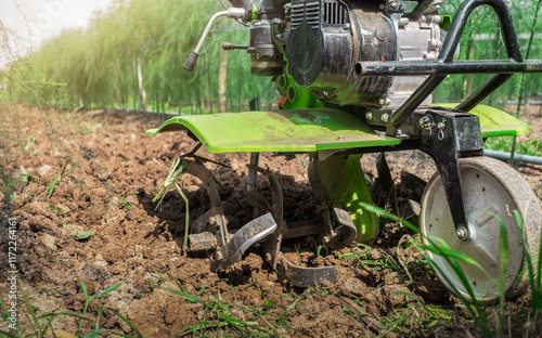 Farmer with ploughs ground in sunny day.  preparing land with seedbed cultivator as part of pre seeding activities in early spring season of agricultural works at farmlands. photo