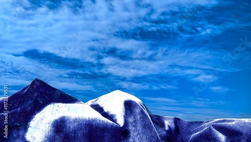 Digitally generated image: Abstract nature photograph of a mountain range covered in snow against a backdrop of a bright blue sky with wispy clouds.