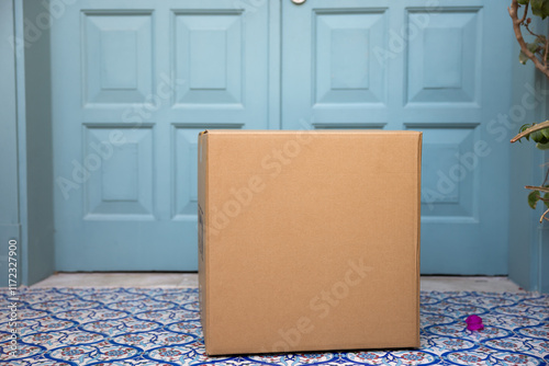 Bilde på lerret Postal cardboard box placed at front door on house doorstep by courier, deliveryman, delivery service worker