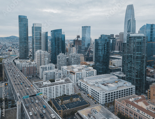 Aerial view of downtown San Francisco with modern skyscrapers, including Salesforce Tower, and busy freeway traffic under cloudy skies. photo