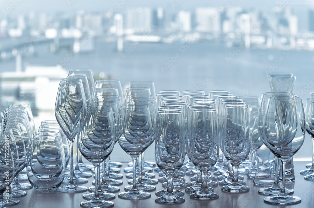Wine and Drink glasses are arranged in front of drinks counter bar with cityscape background