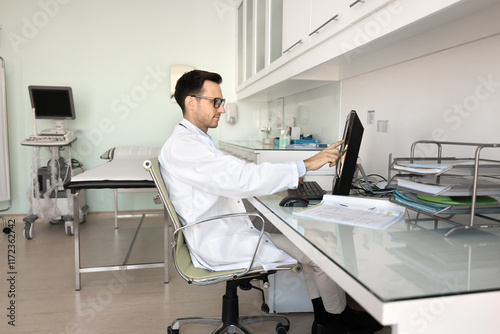 Wallpaper Mural Serious ultrasound diagnosis medical specialist reviewing scan results on computer, working at desktop, sitting at workplace table in examination room pointing at monitor Torontodigital.ca