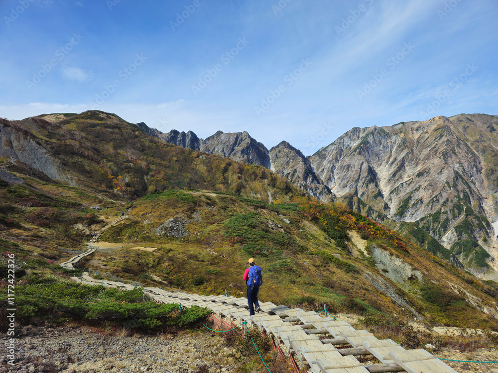 An unrecognizable man hikes towards Happo Pond in the mountains of Hakuba, Nagano prefecture, Japan. An unrecognizable man hikes towards Happo Pond in the mountains of Hakuba, Nagano prefecture, Japan.