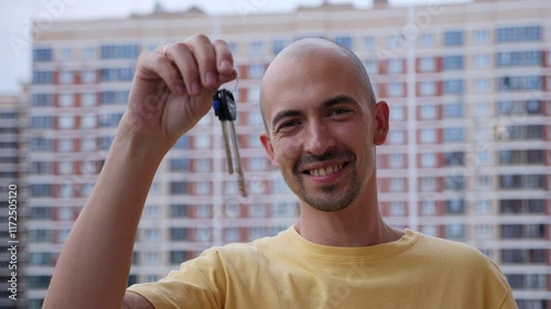 Wallpaper Mural An adult man with the keys to a new apartment against the background of a new modern residential complex, he holds the keys and smiles. Torontodigital.ca