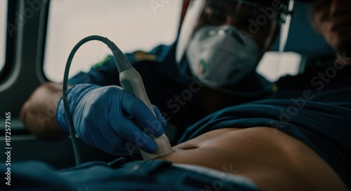 Paramedic performing ultrasound on patient in ambulance