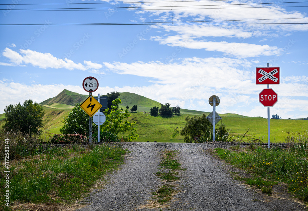 Railway crossing sign, stop sign and powerline above sign at the railway crossing.