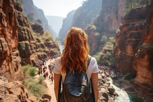 Adventurous Girl with Backpack Overlooking a Majestic Canyon and Rushing River photo