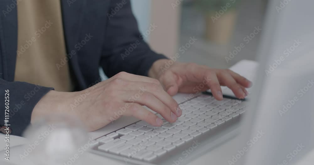 Close-up of male hands typing with computer keyboard at desk in office. Businessman working online sitting at table in workplace with modern device.