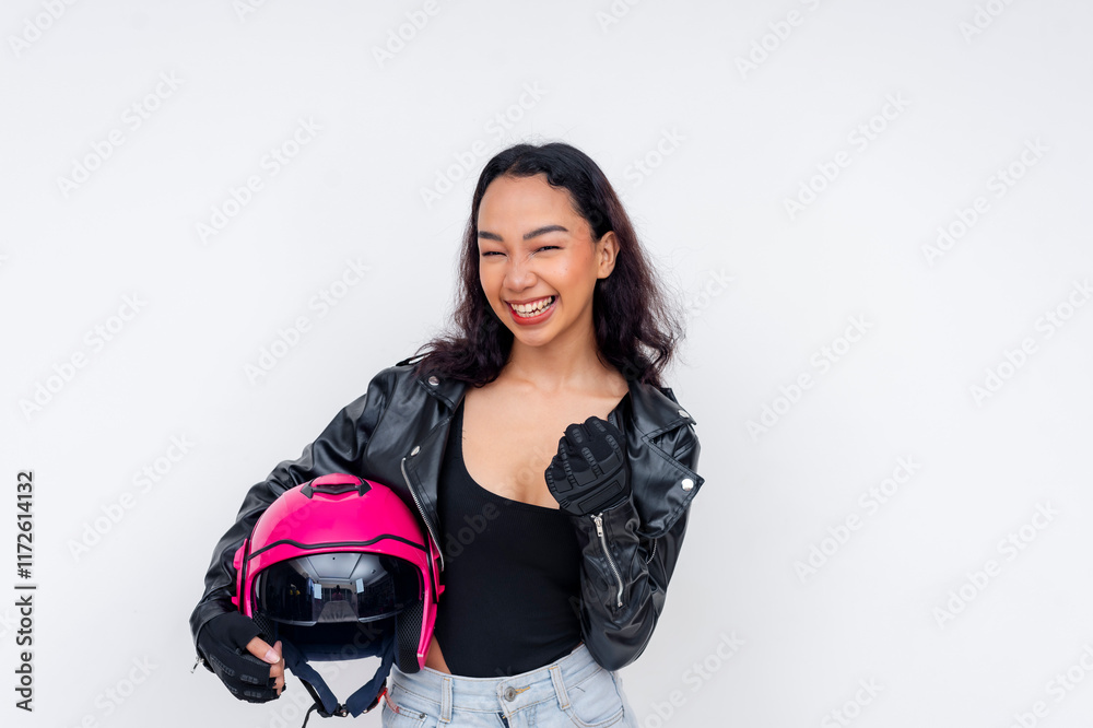 A young female motorcycle rider excited for a joyride, holding her pink helmet and pumping her fist. Isolated on a white background. A young female motorcycle rider excited for a joyride, holding her pink helmet and pumping her fist. Isolated on a white background.