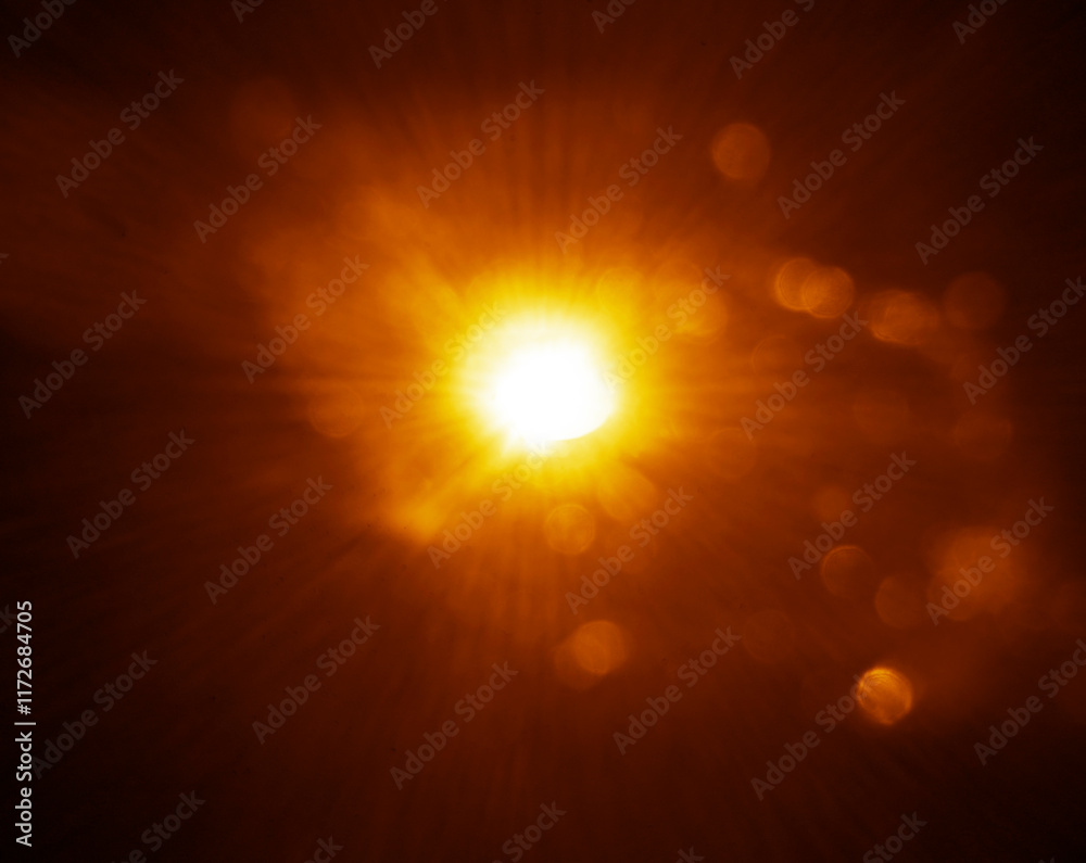 Obraz premium blurred image. shiny sun, sunbeams, sunrays, sunshine design. Yellow orange warm light effect, sun rays, golden beams isolated on black background. star dust