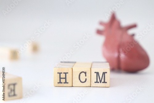 HCM letters written on wooden blocks isolated with heart on white background. Hypertrophic Cardiomyopathy concept of cardiology disease