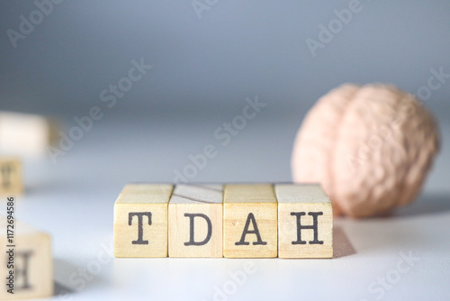 TDAH acronym mental health disease written on isolated wooden cubes with a brain on white background with copy space. photo