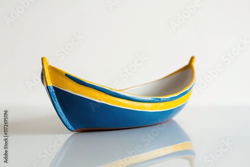 polished studio composition of miniature replica of traditional portuguese fishing boat painted in vibrant blue and photo